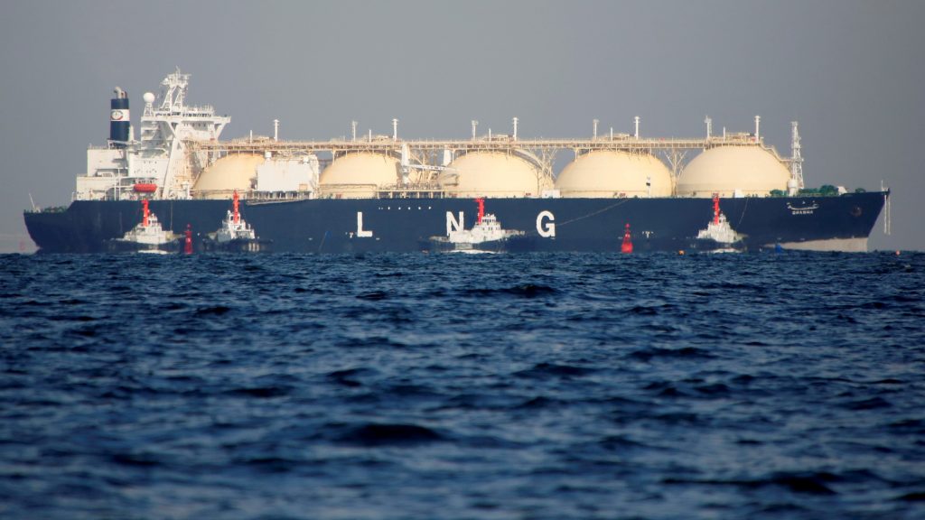 An LNG tanker is tugged towards a thermal power station in Futtsu