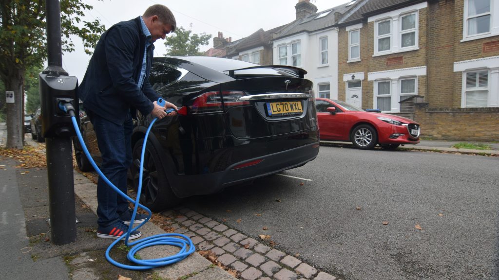 Richard Stobart, CEO of an electric vehicle charging system startup company Char.gy, demonstrates one of the company's lamp post chargers in London